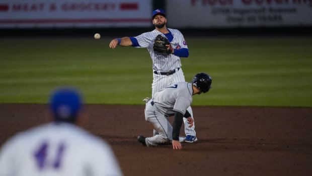 Iowa Cubs second baseman David Bote (13) throws the ball to first baseman Matt Mervis (41) to try and get a double play during the season opener at Principal Park in Des Moines on Friday, March 31, 2023. The Cubs defeated the Clippers, 11-5.